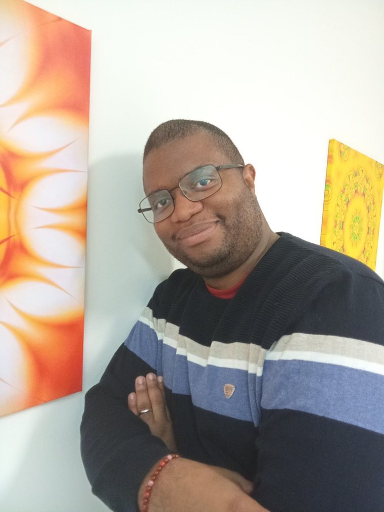 Romaric, devant deux toiles aux motifs solaires